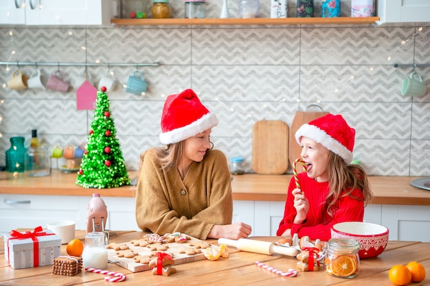 Little girls cooking Christmas gingerbread. Baking and cooking with children for Christmas at home.