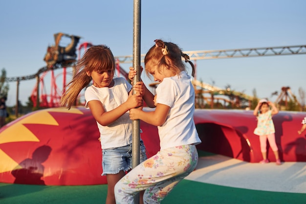 Little girls have fun at children's amusement park at daytime