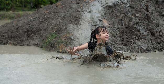 Маленькие девочки весело играют в грязи на общественных полях.