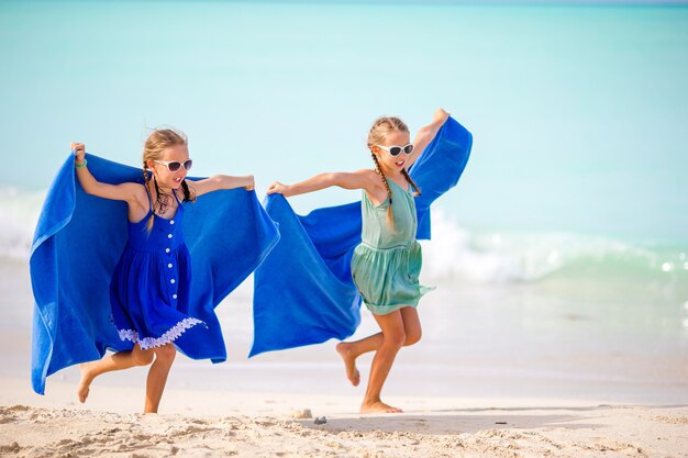 Little girls having fun enjoying vacation on tropical beach