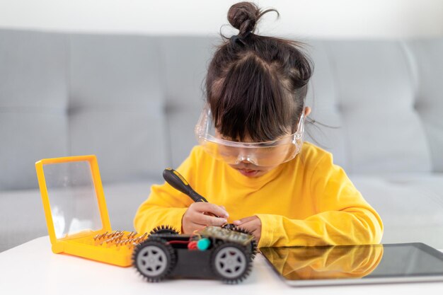 로봇 자동차를 코딩하는 워크샵에서 즐거운 시간을 보내는 어린 소녀들
