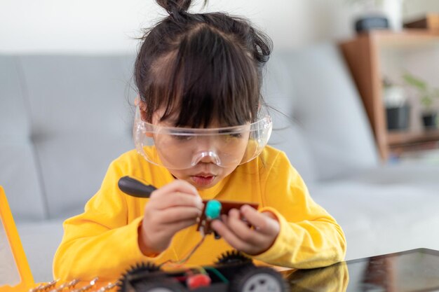 Little girls having fun in a workshop coding robot car