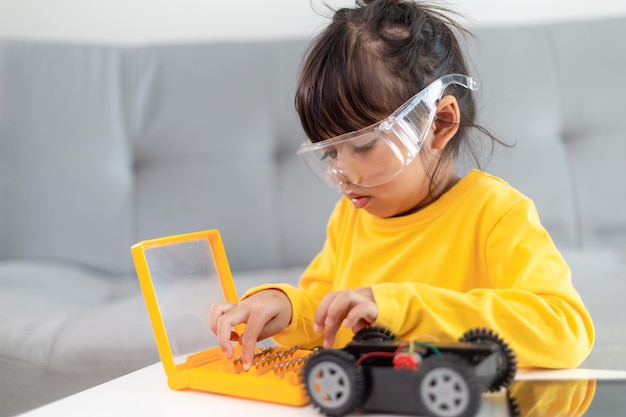 Little girls having fun in a workshop coding robot car