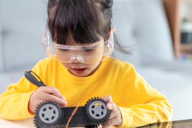 Little girls having fun in a workshop coding robot car