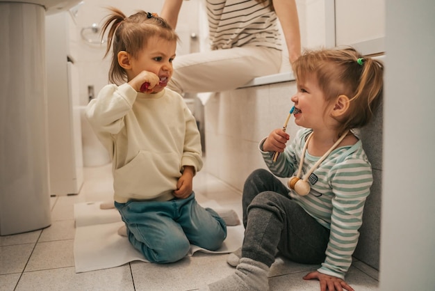 Bambine che si guardano l'un l'altra durante la procedura di spazzolatura dei denti