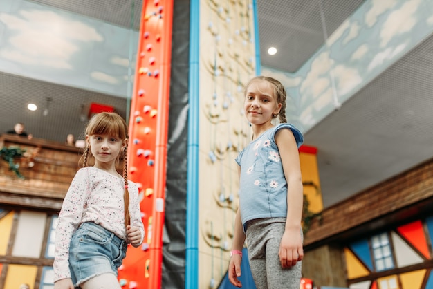 Little girls looks on climbing wall, game center