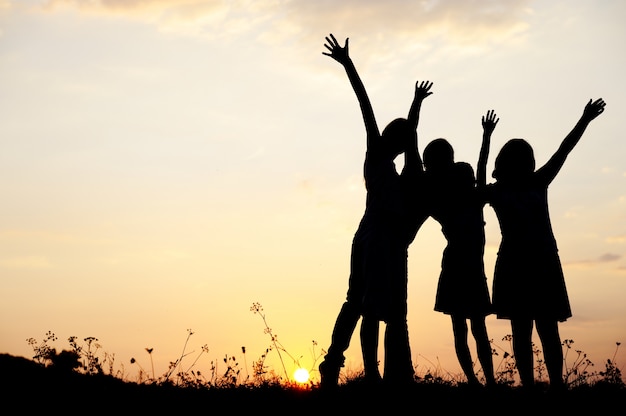 Photo little girls on meadow at sunset, large copy space