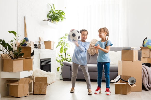 Little girls near cardboard box, moving to a new apartment