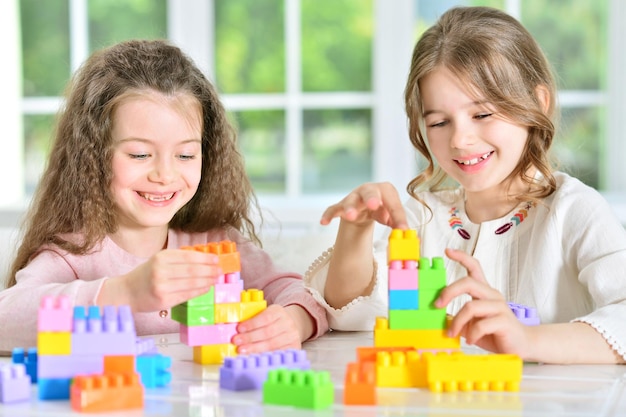 Little girls playing with plastic blocks