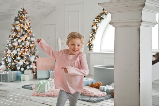 Little girls run around the Christmas decorated house 2066