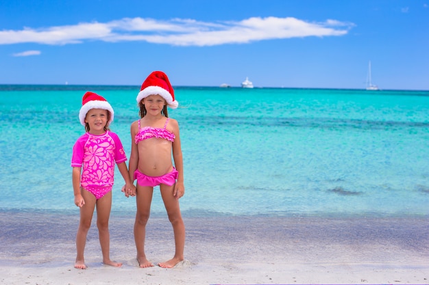 Little girls in Santa hats during summer vacation