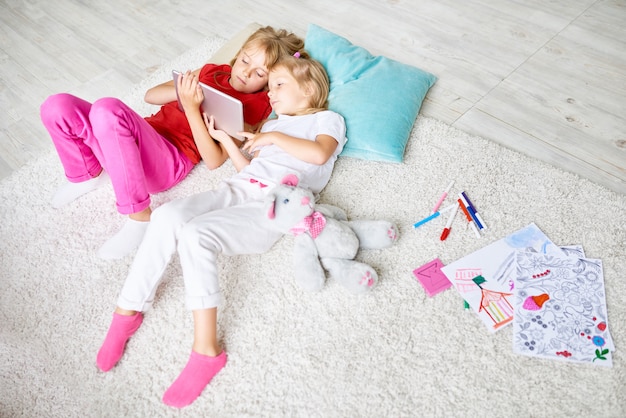 Photo little girls using tablet at home