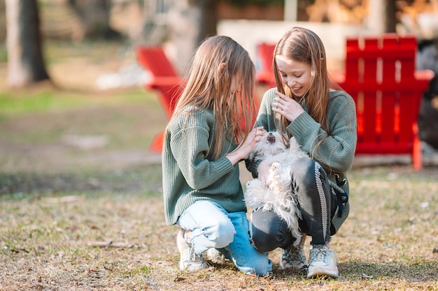 Little girls with a white puppy. A puppy in the hands of a girls