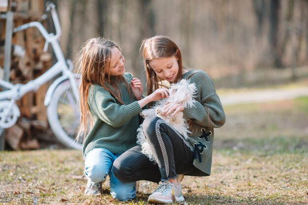 Little girls with a white puppy. A puppy in the hands of a girls