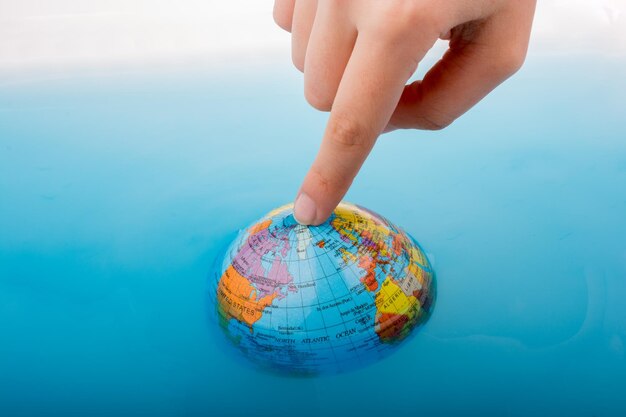 Little globe with finger on top floating