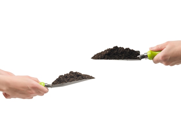 Little green shovel with soil in woman hand isolated