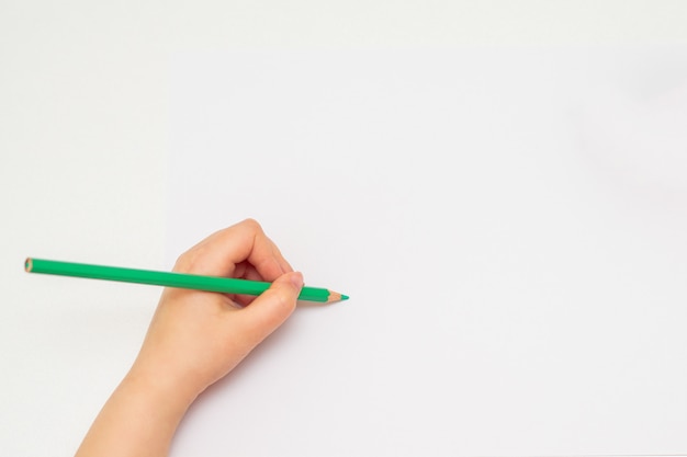 Little hand of girl drawing on paper.