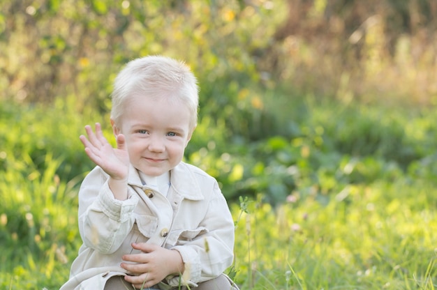 Little happy blond boy outdoor  on sunny summer day