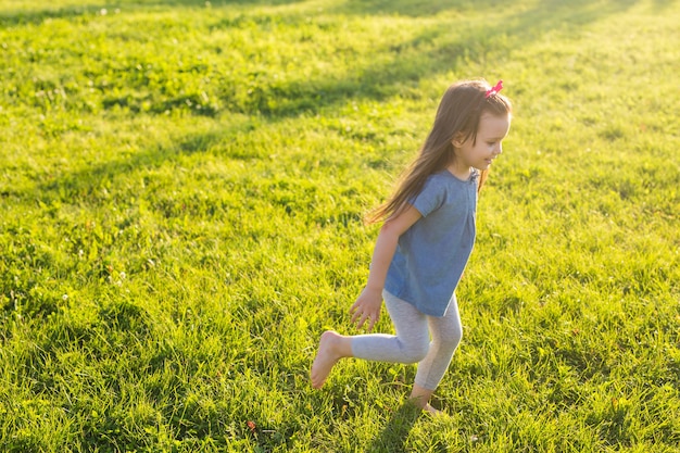 Little happy girl having fun in a summer park