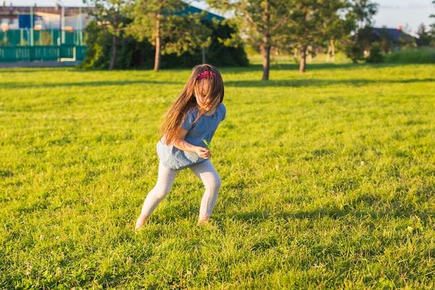 夏の公園で楽しんでいる小さな幸せな女の子