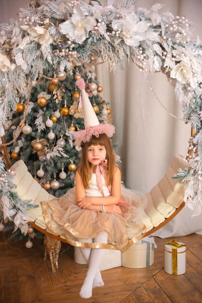 маленькая счастливая девочка возле елки на рождество дома праздничное настроение