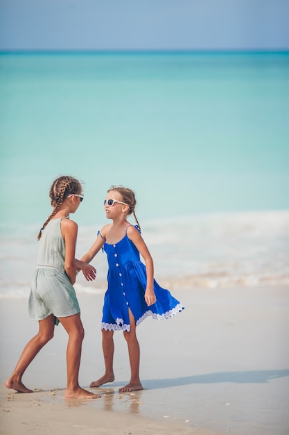 Little happy kids have a lot of fun at tropical beach playing together