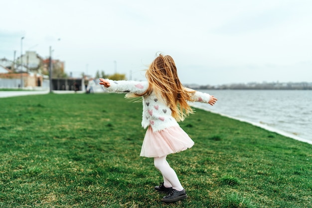 Little happy pretty girl have fun in the park