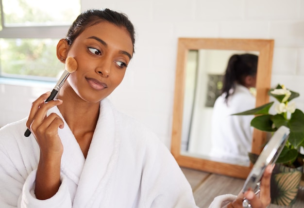 A little here and a little there Shot of a beautiful young woman going through her makeup routine at home