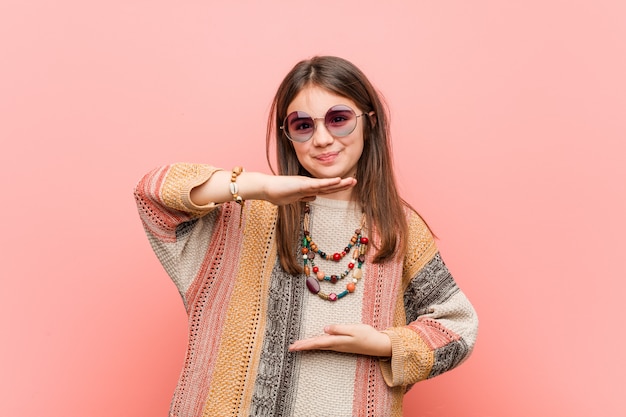 Little hippie woman holding something with both hands, product presentation.