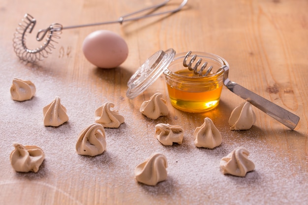 Little honey meringues on a wooden table