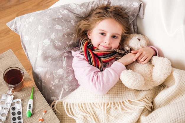 Little ill girl sleep hugging teddy bear