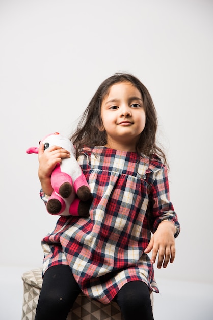 Little Indian asian girl playing with stuffed soft toy