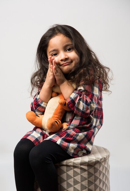 Little Indian asian girl playing with stuffed soft toy