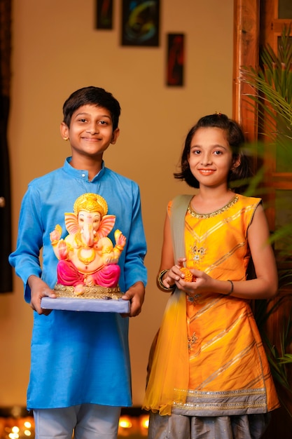 Little indian siblings with lord ganesha.