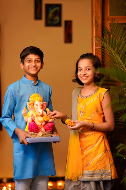 Little indian siblings with lord ganesha.