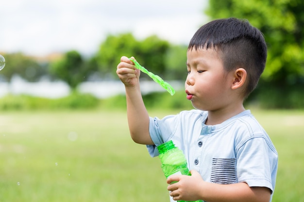 Little kid blowing soap bubbles