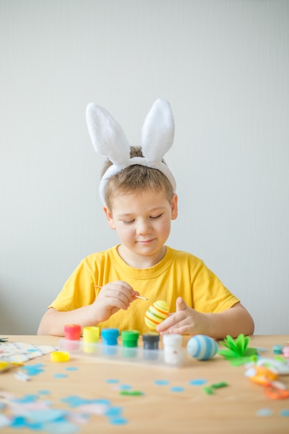 Little kid boy painted  easter egg. DIY  for easter holidays with kids.  Craft for spring