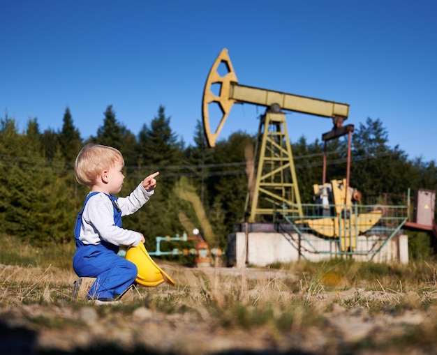 Little kid boy pointing finger at oil rig