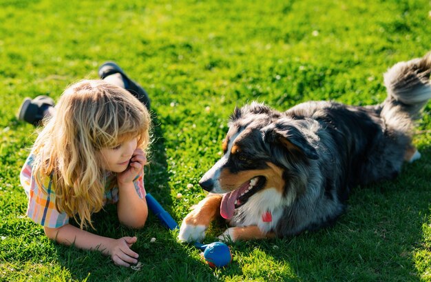 Фото Маленький мальчик с собакой на траве