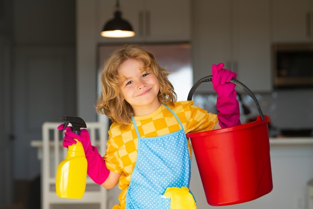 Little kid cleaning at home Child doing housework having fun Portrait of child housekeeper with wet flat mop on kitchen interior background