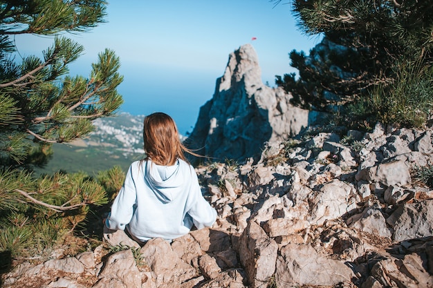 Little kid on edge of cliff in mountains