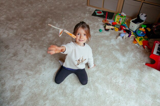 折り紙紙飛行機を飛んでいる小さな子供