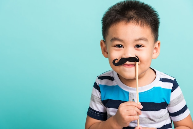 little kid holding black mustache props for the photo booth