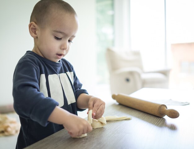 小さな子供が自宅で食べ物を作っている