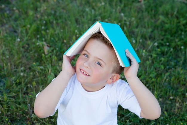 Little kid playing with a book at outside