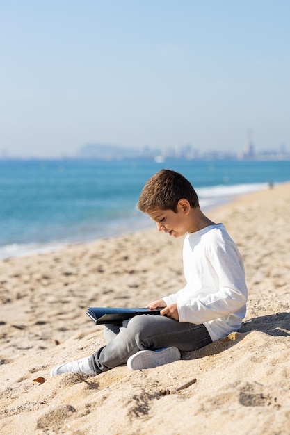 Little kid reading a book on the beach