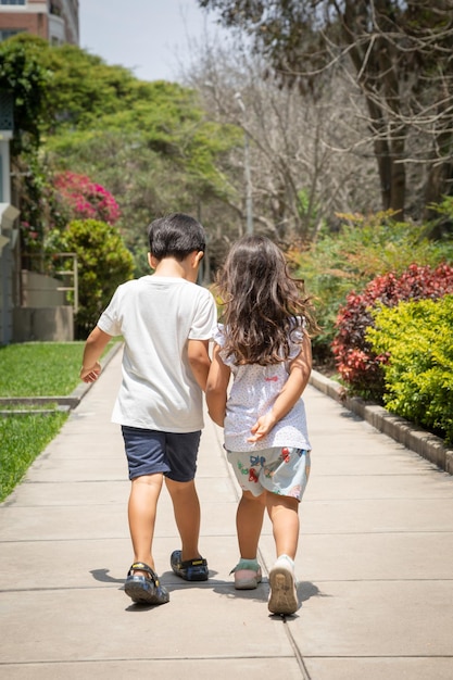 公園で楽しく走っている小さな子供子供の自由