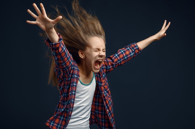 Photo little kid screams in studio, developing hairstyle