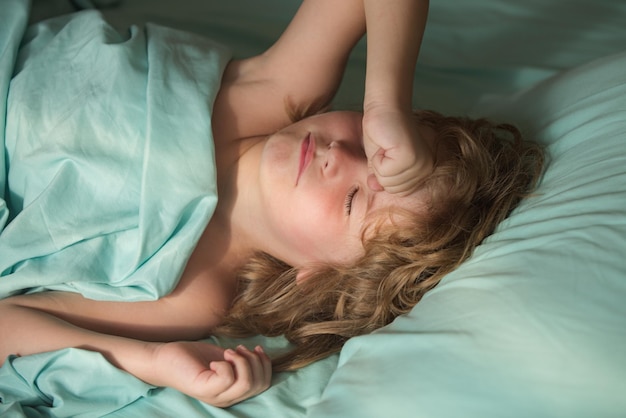 Little kids boy sleeping on the bed