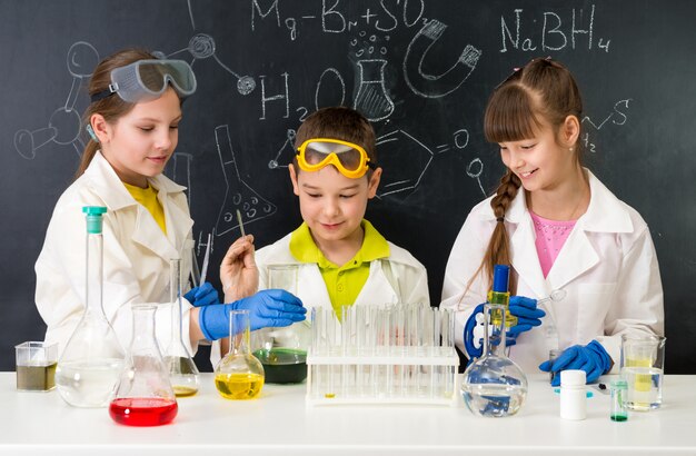 Маленькие дети на уроке химии в лаборатории
